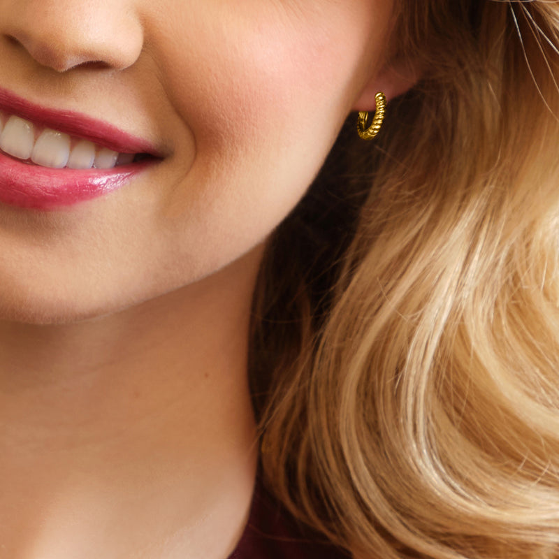 Gold shrimp-texture huggie hoop earring close-up, small ridged hoop