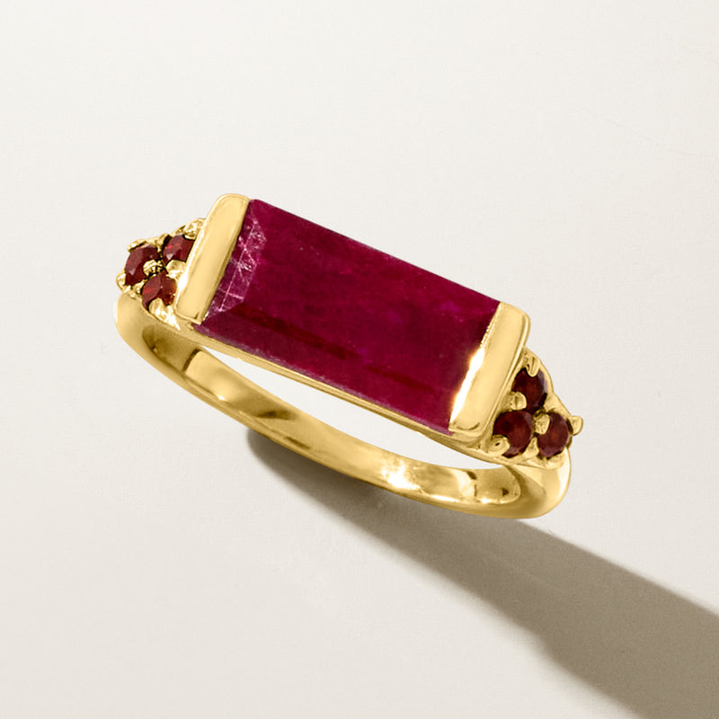 Gold ring with rectangular ruby center set in bezel with clustered garnet accents