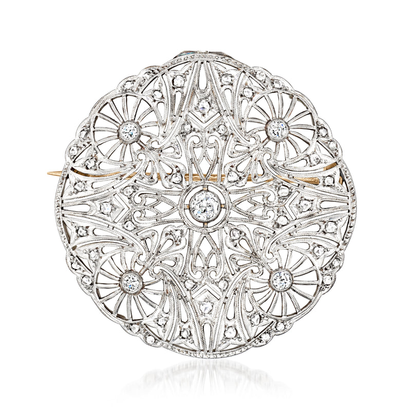 Close-up of round filigree diamond pendant with scalloped edge and halo stones