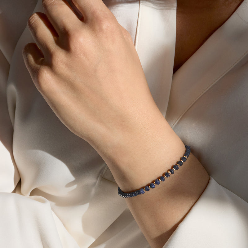 Sapphire bead bracelet on wrist with 10kt yellow gold clasp