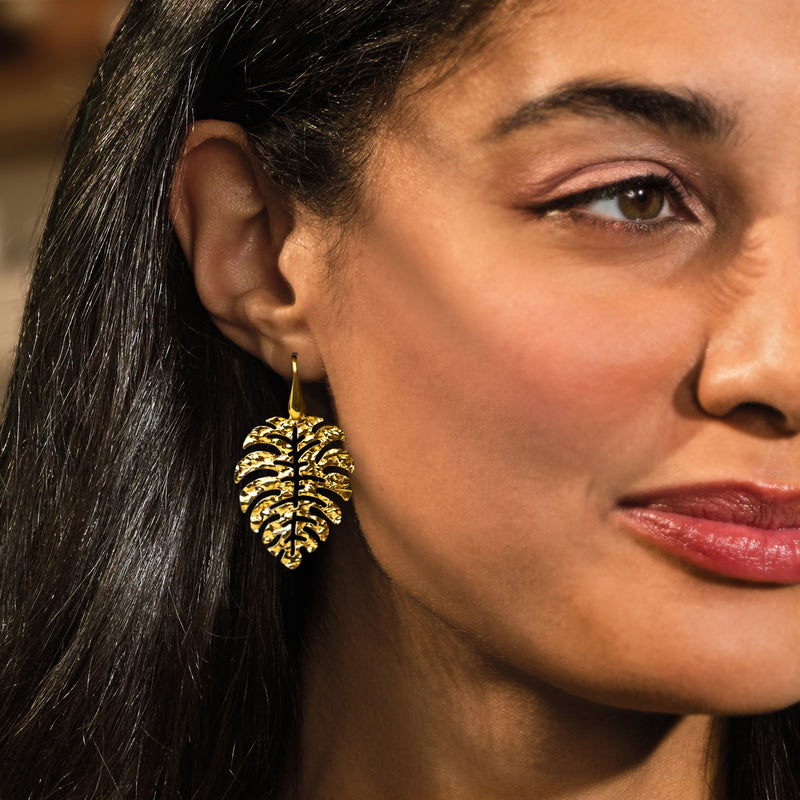 Gold-tone hammered leaf drop earrings on earwire, worn by a model