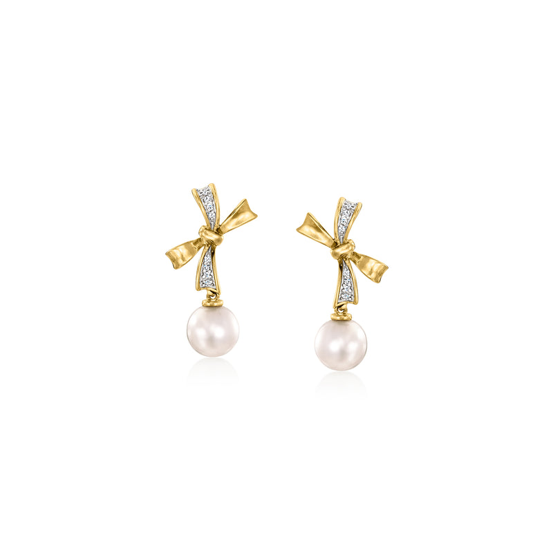 Gold bow drop earrings with diamond-like accents and a white pearl drop