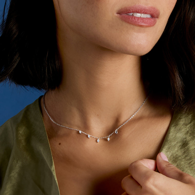 White gold marquise-cut diamond station necklace worn at collarbone