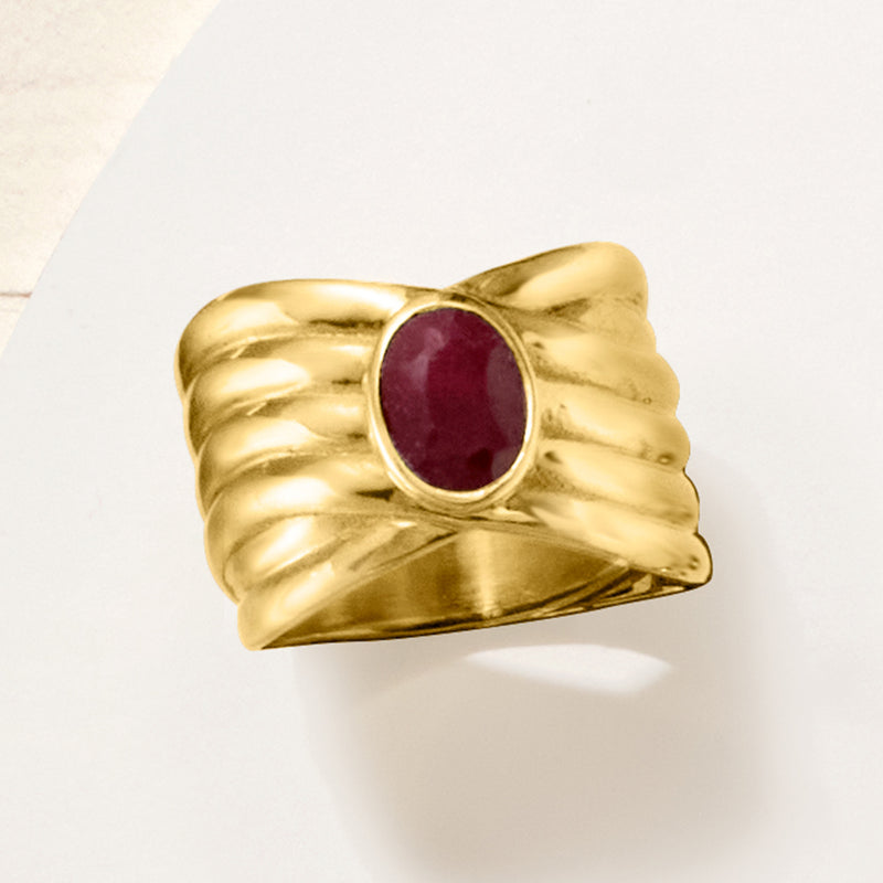 Gold crisscross ring featuring an oval ruby cabochon in a round bezel