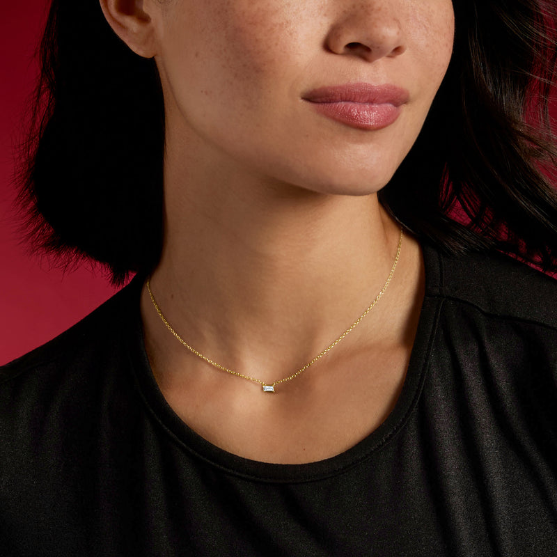 14kt yellow gold baguette diamond necklace, rectangular pendant on neck close-up