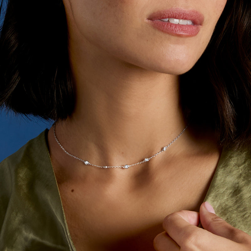 14kt white gold station diamond necklace close-up, round stones on a delicate chain