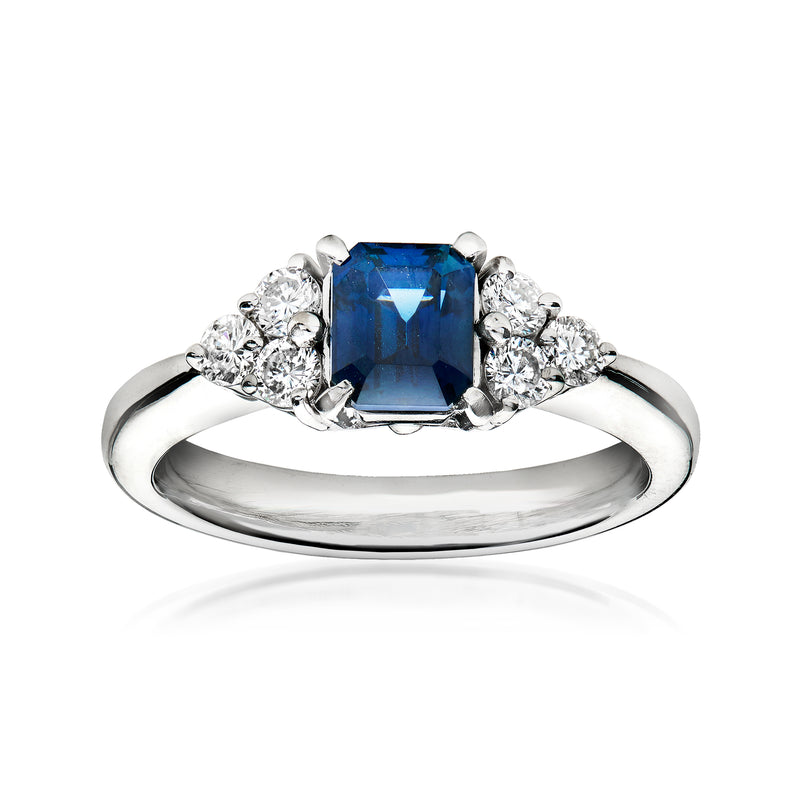 Platinum ring with cushion-cut blue sapphire and round diamond side clusters
