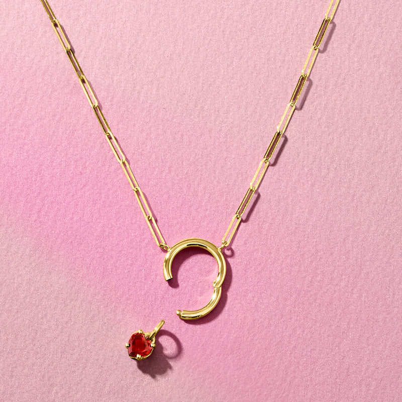Gold necklace with red garnet heart charm and open-loop charm pendant