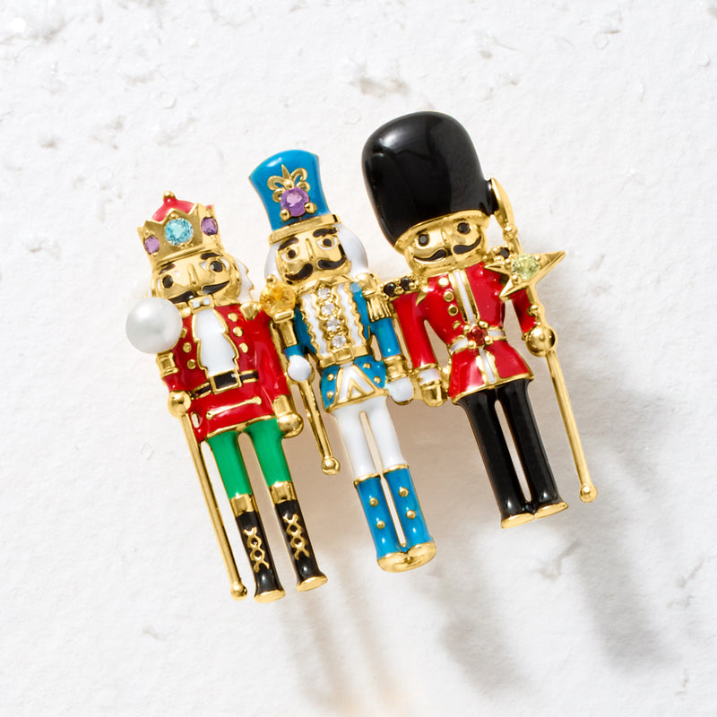 Nutcracker pin featuring three enamel soldiers in red, blue, and black with white pearl