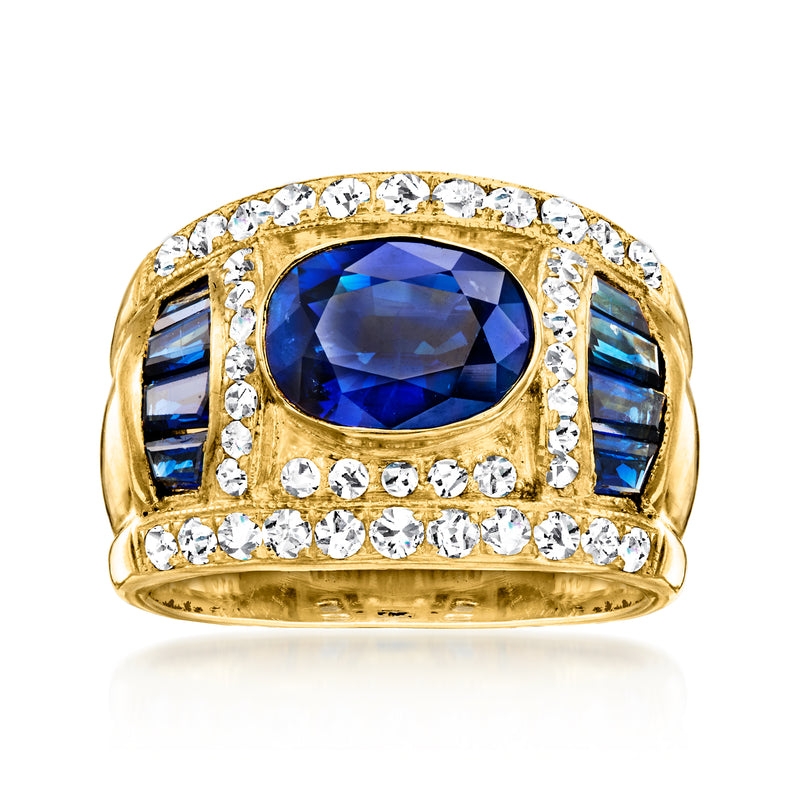 18kt yellow gold ring with large blue sapphire center, diamond halo, blue side stones