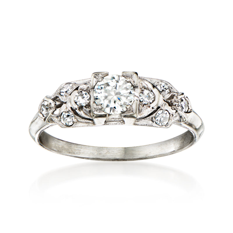 Vintage 18kt white gold diamond ring with round center stone and floral accents