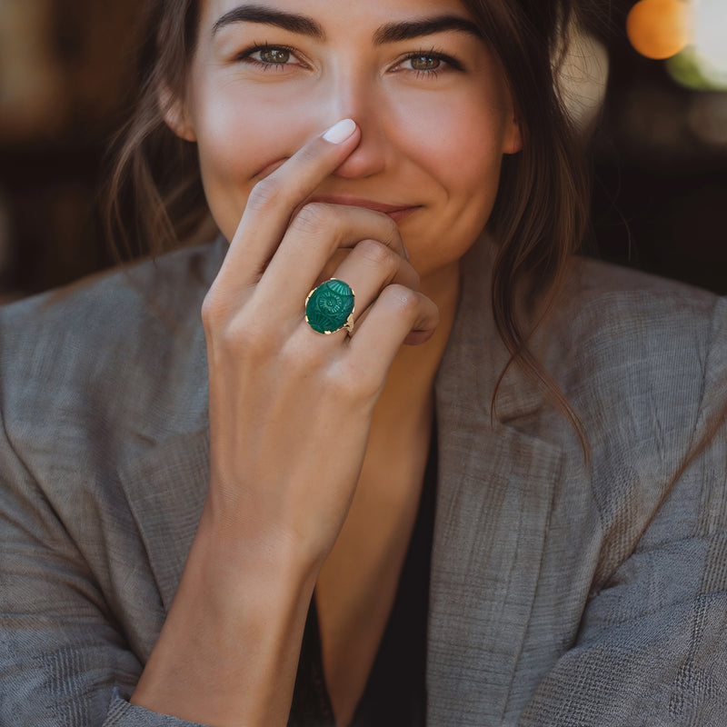 Green chalcedony cabochon ring in 10kt yellow gold on finger, oval centerpiece