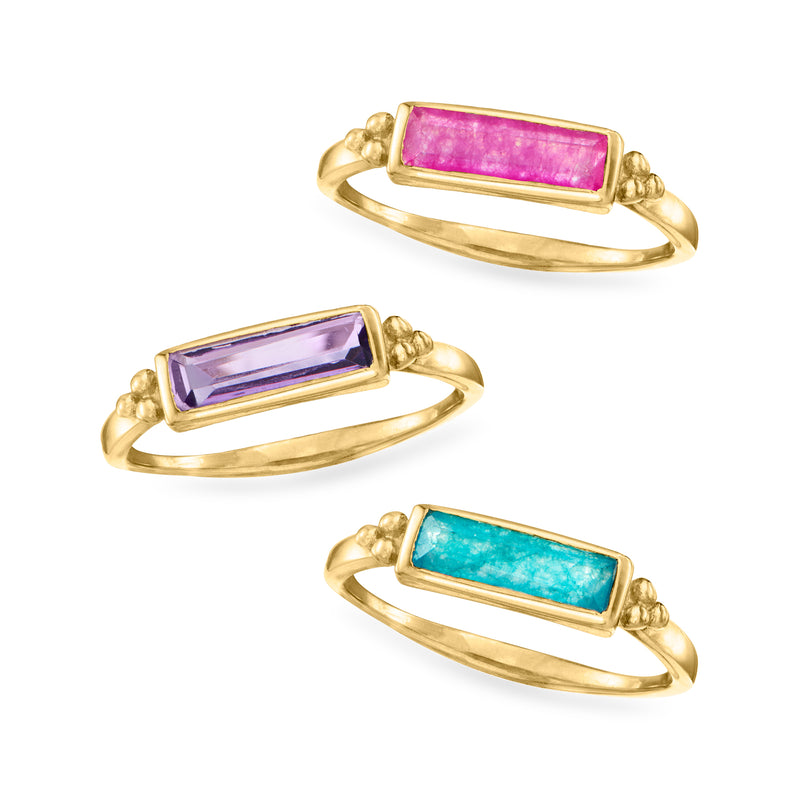 Three gold-tone rings displayed: rectangular pink, purple, and turquoise gemstone stones