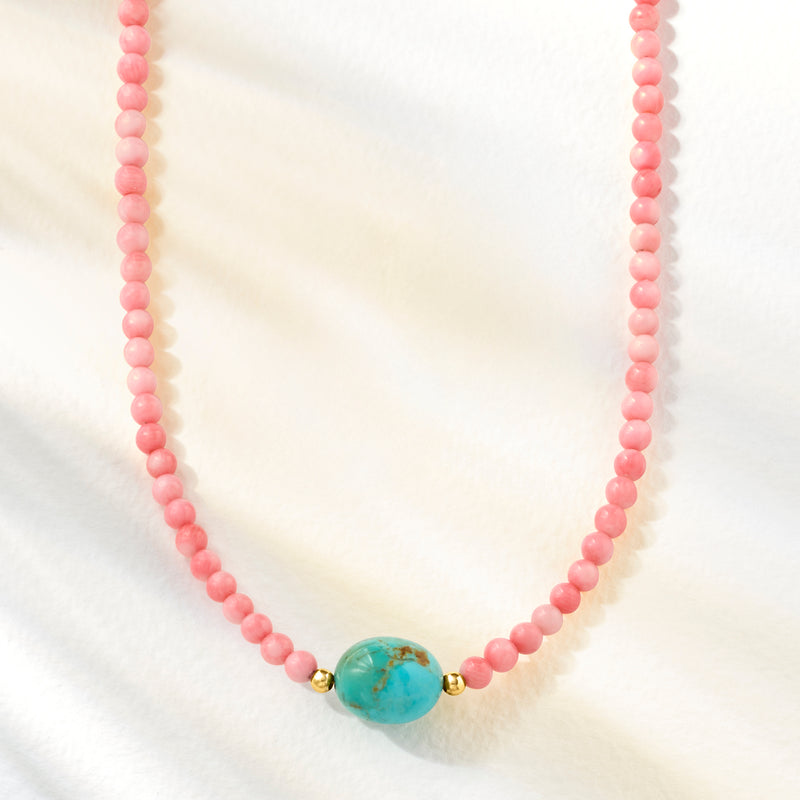 Pink coral bead necklace with turquoise oval center and small gold beads at sides