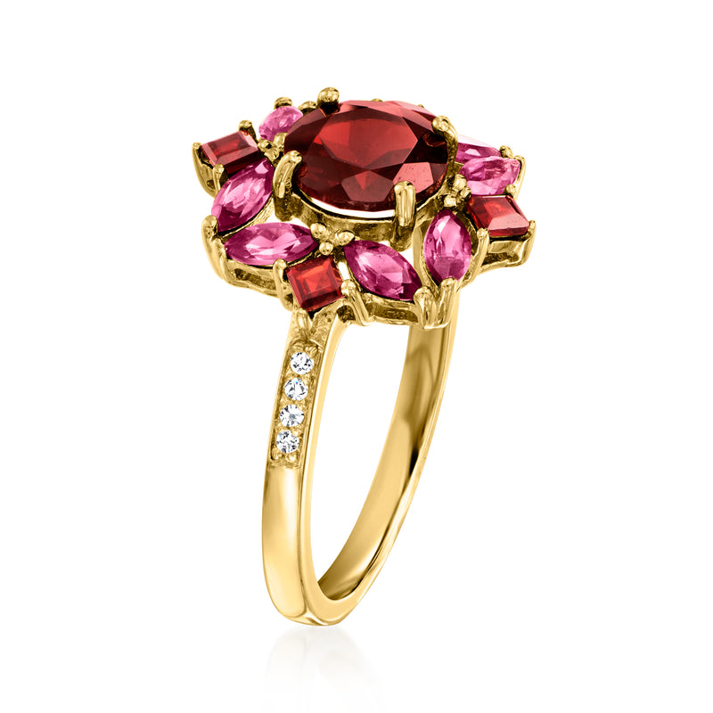 Gold ring with pink and red gemstones; dark center stone, gold band with white accents