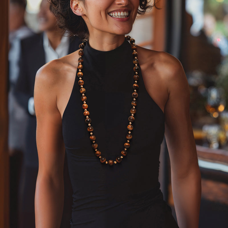 Tiger eye bead necklace with yellow gold-tone beads, worn in a long loop
