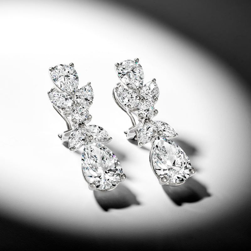 Diamond drop earrings with pear-shaped stones, angled view showing settings