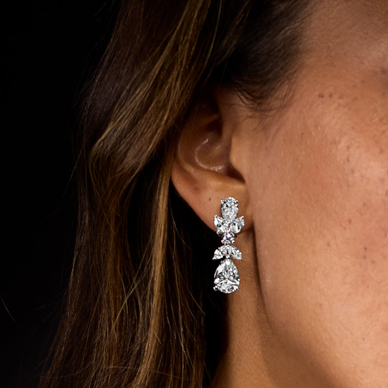 Diamond drop earrings with three pear-cut stones, close-up side view