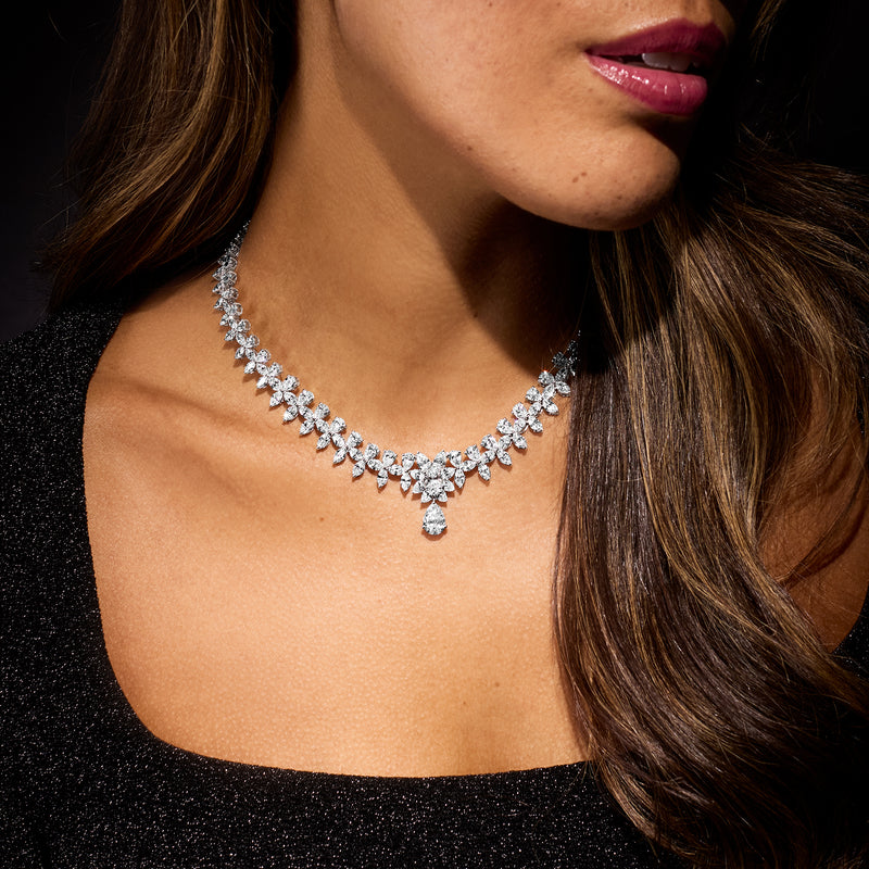 White gold diamond necklace worn at neckline, marquise row with pear-shaped center drop