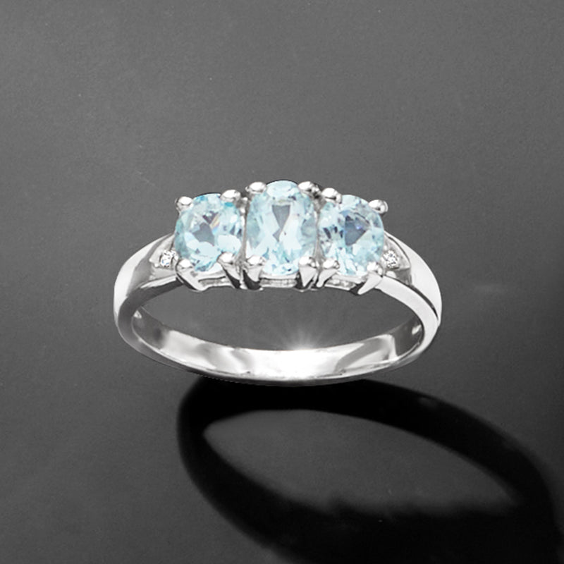 Three-stone aquamarine ring with diamond side stones in sterling silver, angled top view