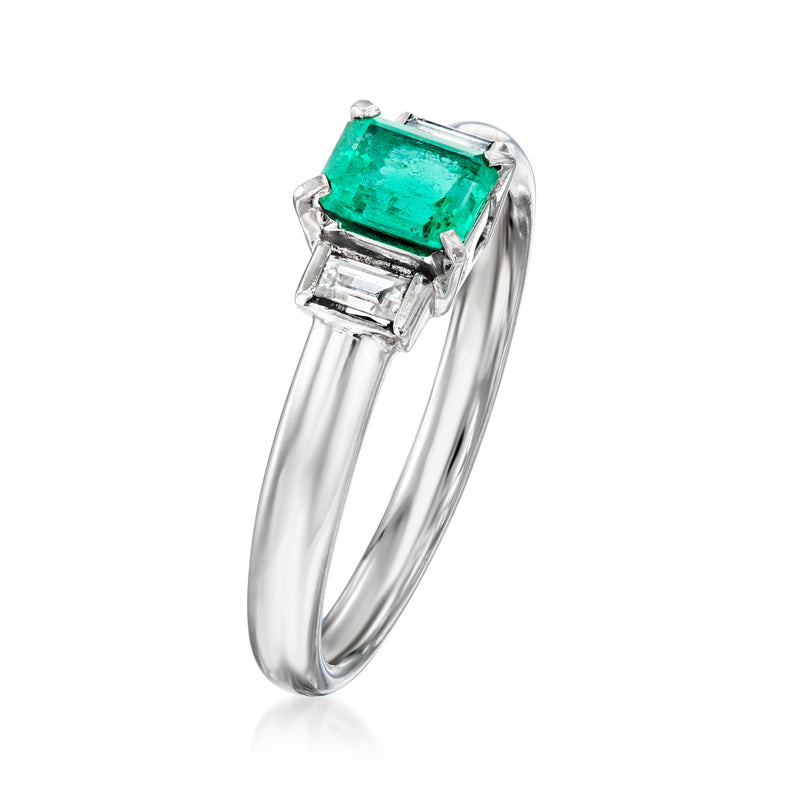 Side view of platinum ring with emerald-cut green center and square diamond accents