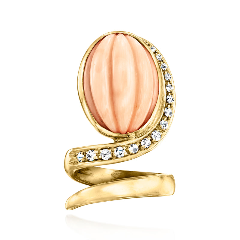 Oval pink coral cocktail ring in 18kt yellow gold with diamond side halo accents