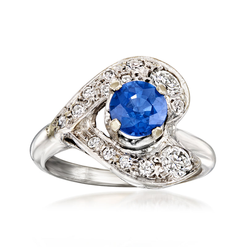 Vintage white gold ring with oval blue sapphire center and diamond halo, milgrain setting.