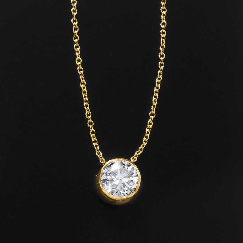 Round bezel-set diamond pendant on 14kt yellow gold chain, angled view