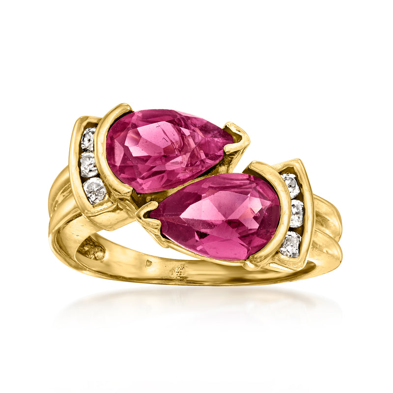 14kt yellow gold bypass ring with two pink oval rhodolite gems and diamond side stones