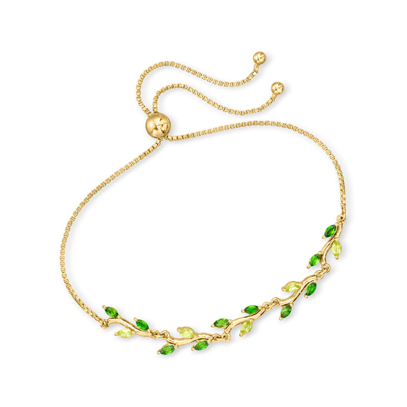 Gold tone bolo bracelet with round ends and green leaf station stones along chain