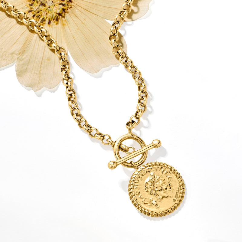 Gold coin pendant necklace with textured round coin and linked toggle clasp, close detail