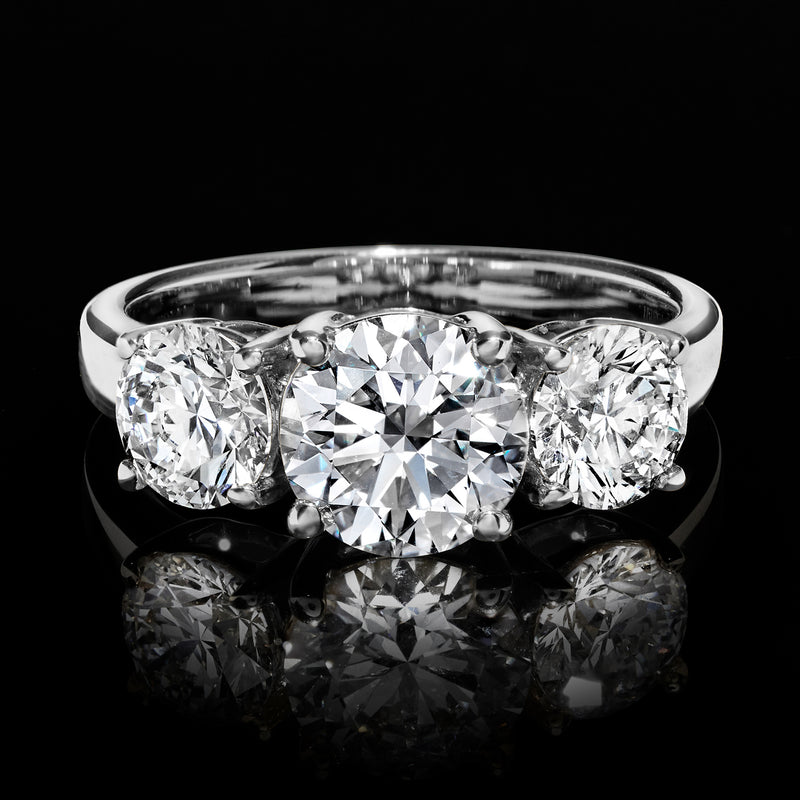 Close-up of 14k white gold three-stone ring with center round lab-grown diamond and two side diamonds