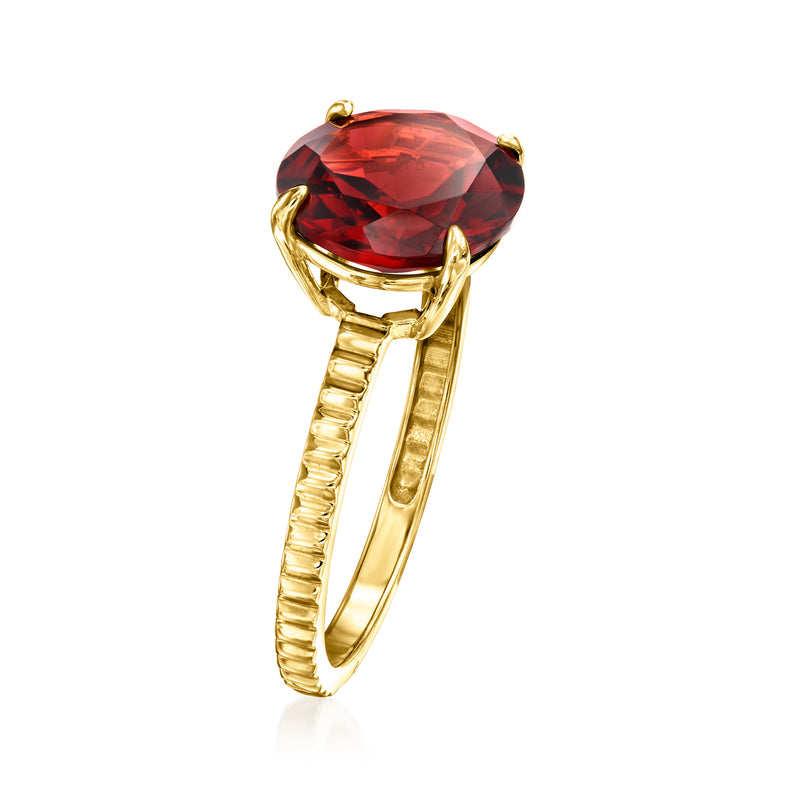 Yellow gold ring with oval red garnet centerpiece and ribbed shank, side view