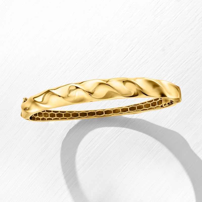 Gold-tone wavy bangle bracelet with snake-textured outer edge and smooth face