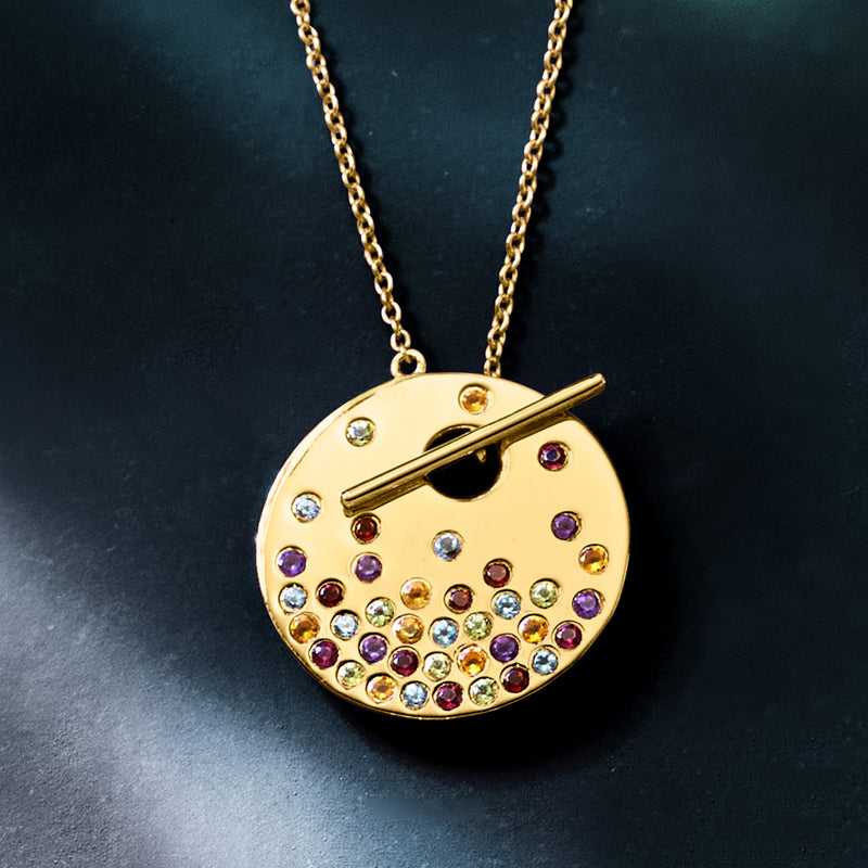 Gold-tone round pendant toggle necklace with bar and scattered multicolor gemstones