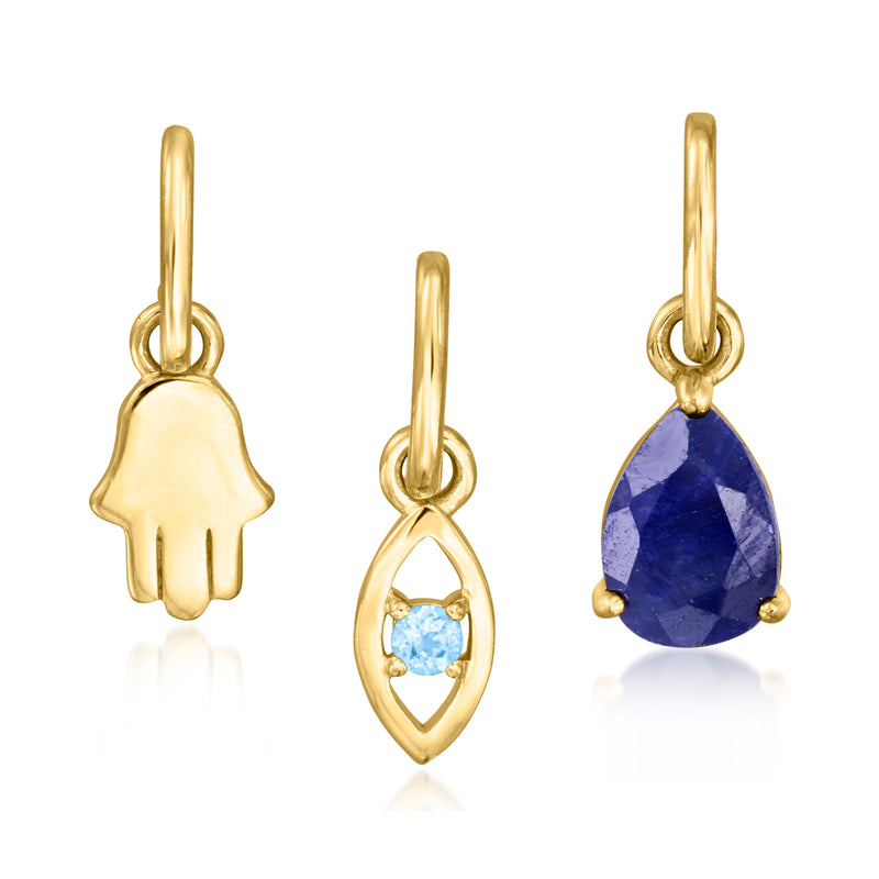 Gold necklace pendants set: hamsa, light blue oval, and faceted blue teardrop