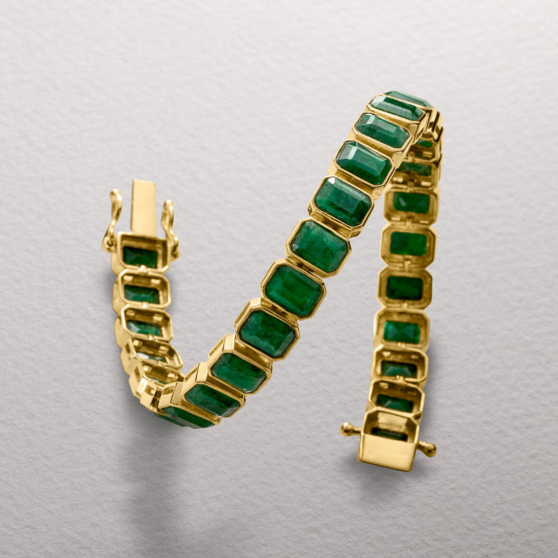 Gold link tennis bracelet with bezel-set green square stones and end clasp