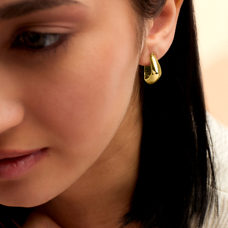 Gold vermeil triangular huggie hoop earring worn on ear, rounded triangular loop