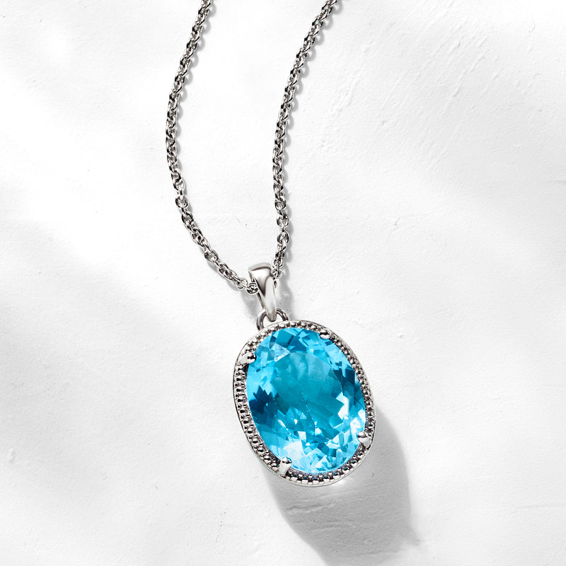 Oval blue topaz pendant on sterling silver chain with sparkling bezel