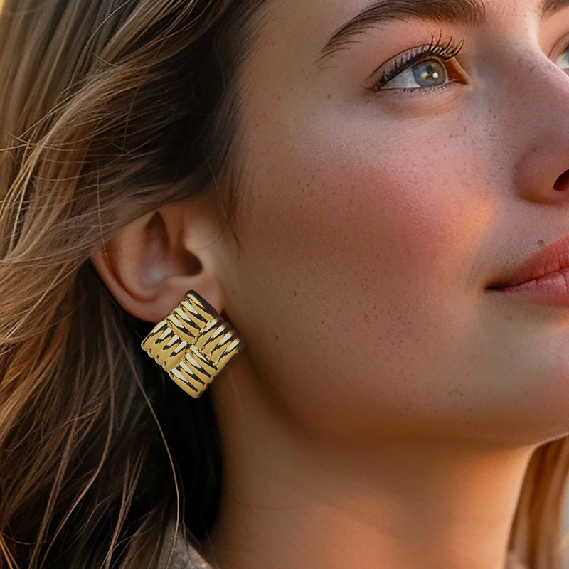 Gold over sterling quilted square stud post earring on ear, close side view
