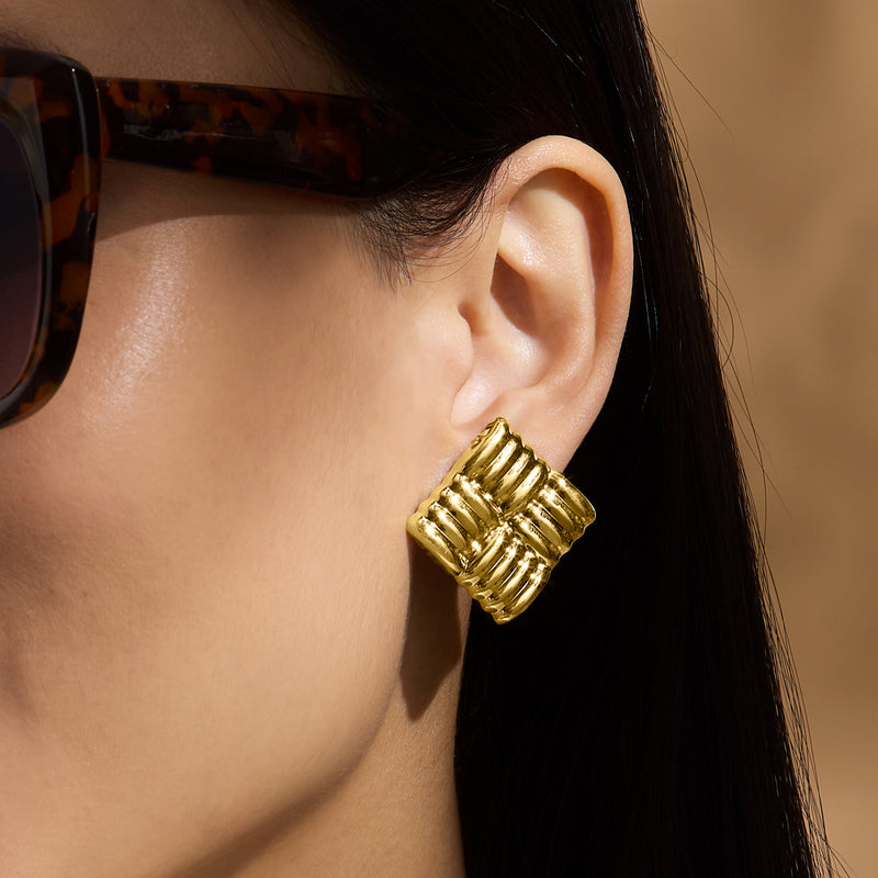 Gold over sterling quilted square stud post earring on ear, detailed ridged texture