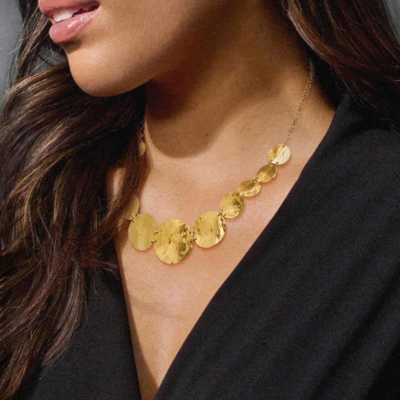 Gold-tone graduated disc necklace on model, round discs with fine chain