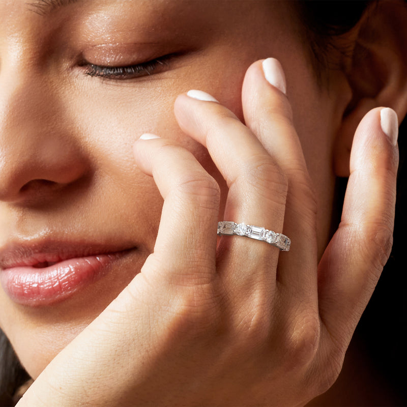 14kt white gold diamond ring on hand, emerald-cut center with round stones