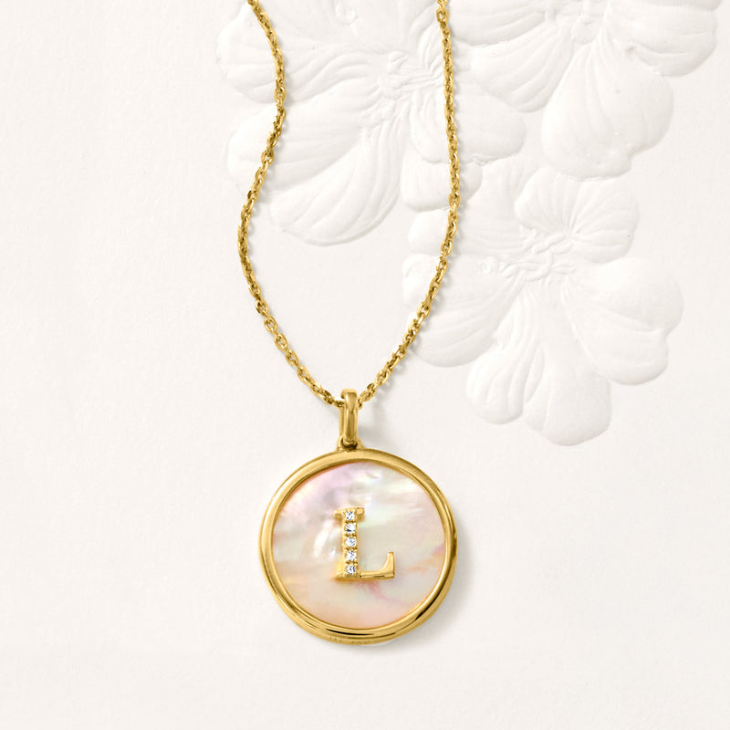Gold-tone necklace with round mother-of-pearl pendant and letter L set with diamonds