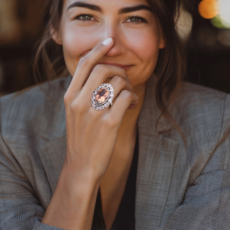 Sterling silver halo ring with oval peach gemstone center and rose gold prongs