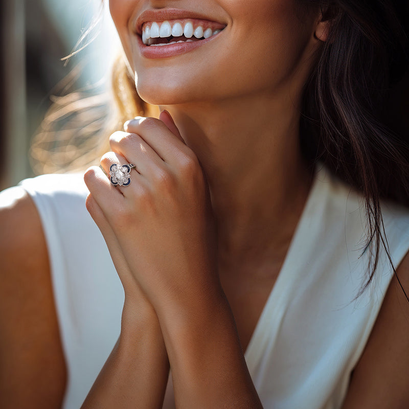 Diamond and sapphire platinum ring worn on finger, with blue halo accents.