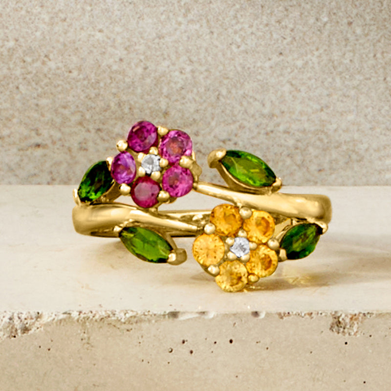 Gold-tone gemstone bypass ring with purple flower top and yellow center with green accents