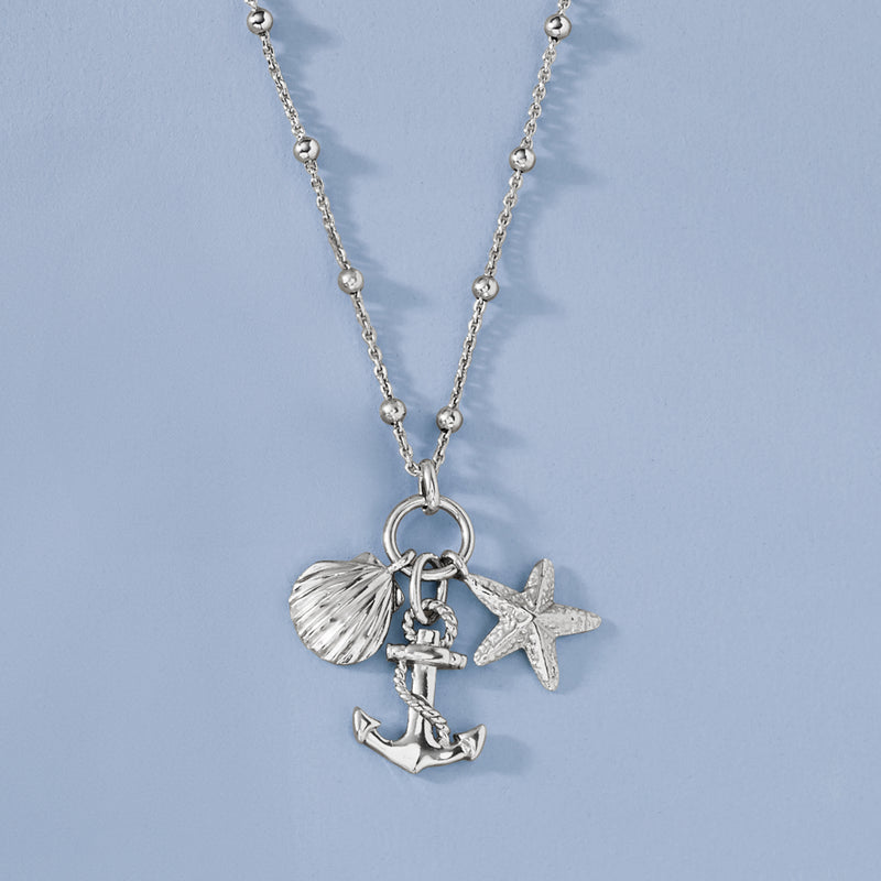 Sterling silver coastal charm necklace with round ring, shell, starfish, and anchor charms