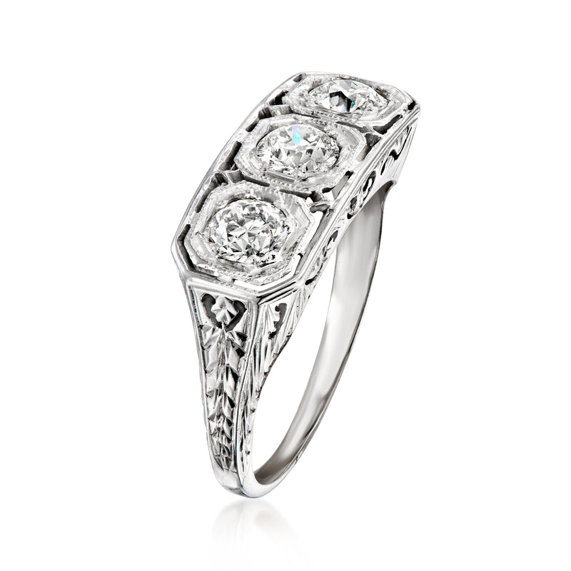 Vintage white gold diamond ring with three round-cut stones and side filigree
