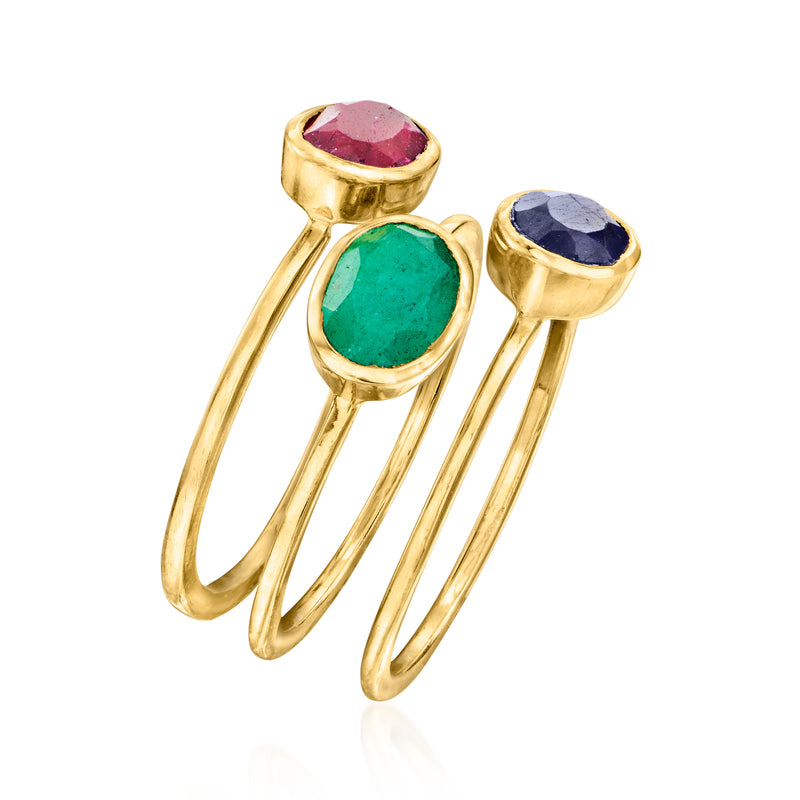 Three gold-tone stacking rings with oval red, green, and blue gemstones